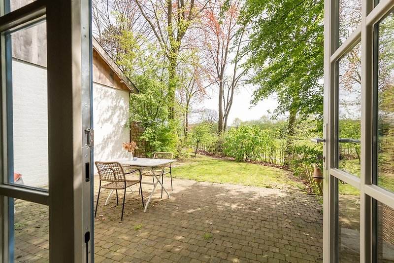 Einladende Terrasse mit Holzmöbeln und Blick auf den Garten.