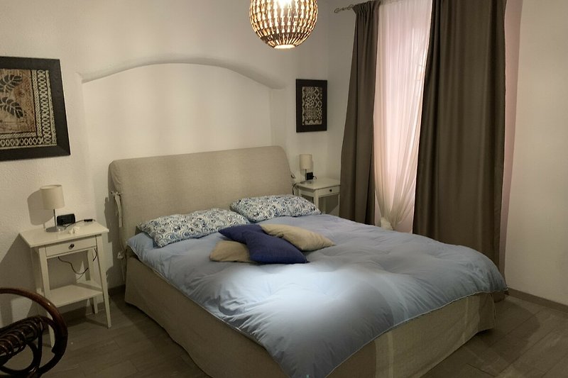 Gemütliches Schlafzimmer mit stilvoller Beleuchtung und gemütlichem Bett.