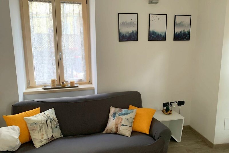 Gemütliches Wohnzimmer mit bequemer Couch, Holzakzenten und stilvoller Beleuchtung.