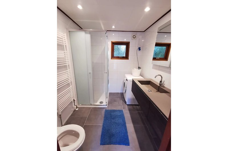 De complete badkamer, met douchecabine en indien nodig, kan een wasje gedraaid worden.
