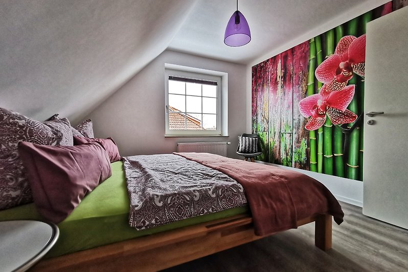 Gemütliches Schlafzimmer mit Doppelbett und farbigen Akzenten.