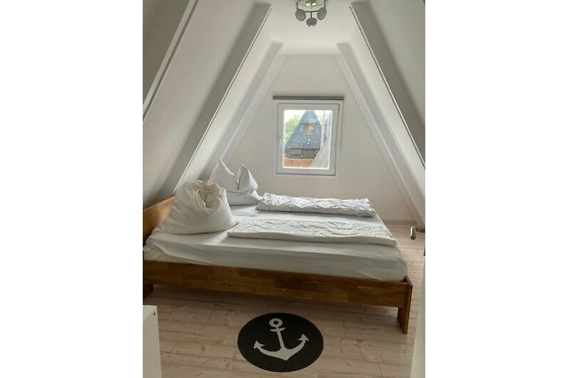 Gemütliches Schlafzimmer mit Holzboden und stilvollem Bett.