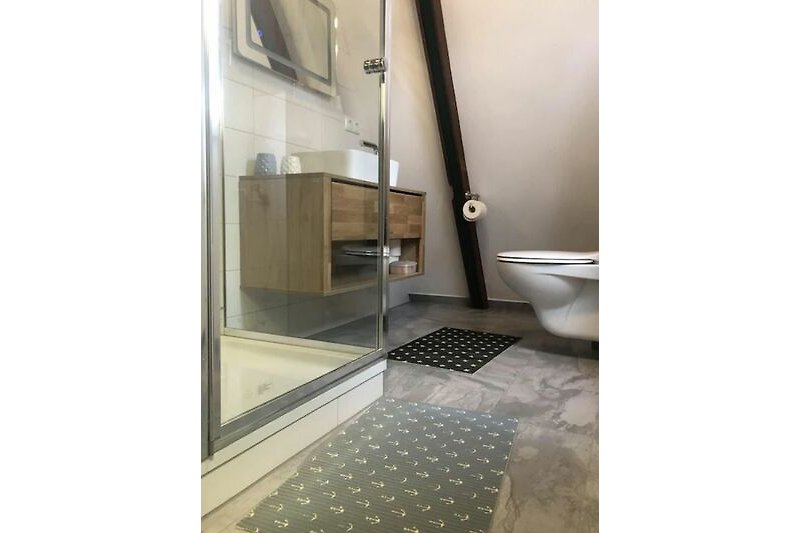 Schönes Badezimmer mit Fliesen, Duschtür und modernem Design.