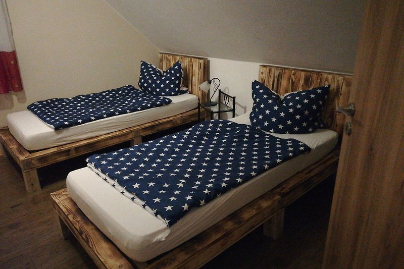 Gemütliches Schlafzimmer mit selbstgebauten Holzbetten