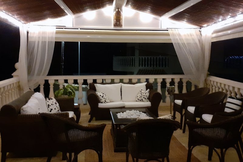 The outdoor living room at night with the possibility to close the sides for extra privacy.
