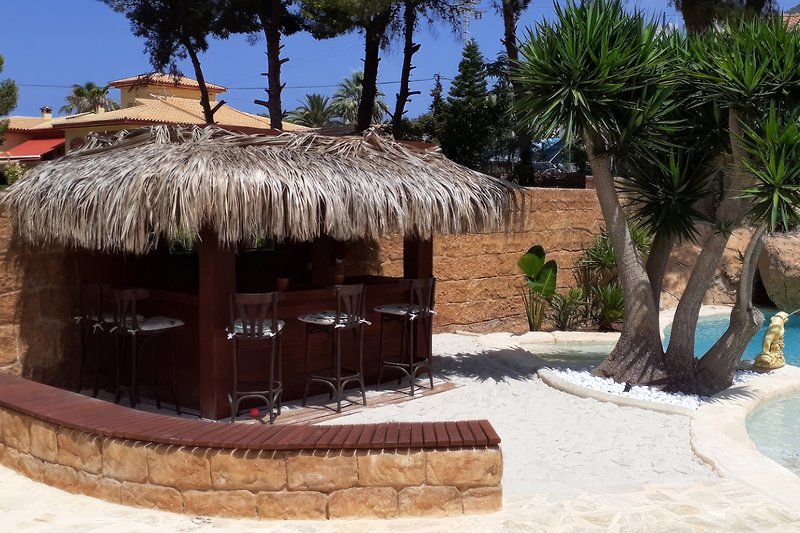 Tiki bar with bar stools, Bluetooth sound system (Onkyo), and a bottle cooler.