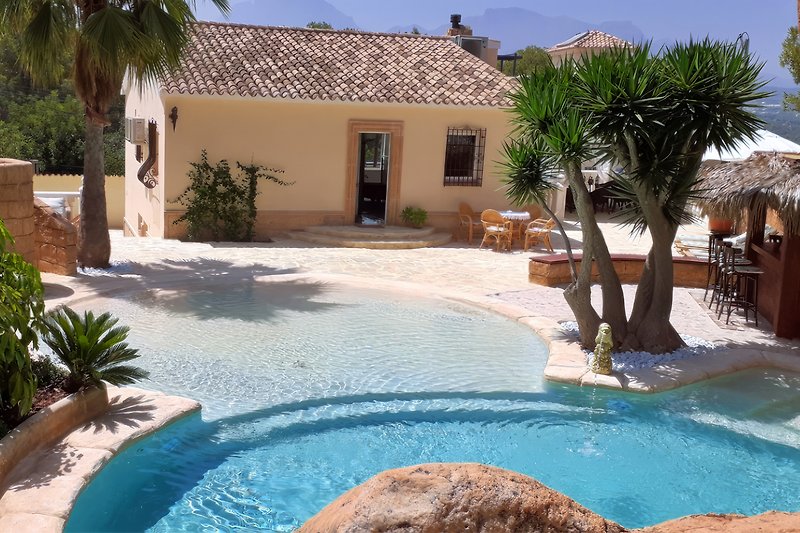 Schönes Haus mit Pool und Blick aufEin Foto vom Hinterhof mit dem Schwimmbad, der Außendusche und der Garten das Wasser.