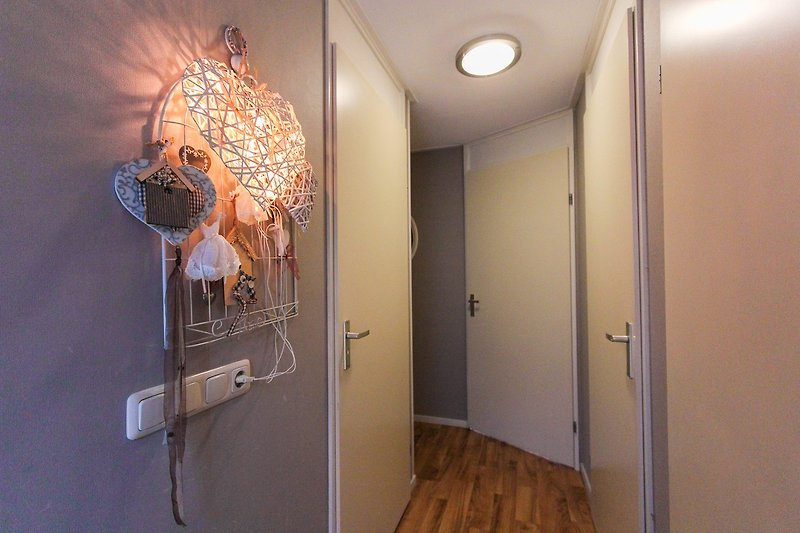 Lichte ruimte met moderne kunst, houten vloer en glazen deur.