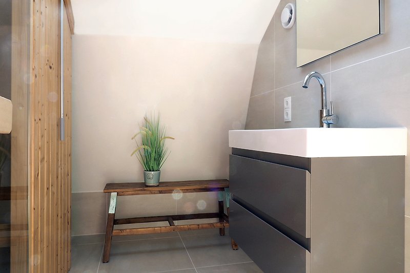 Modernes Badezimmer mit elegantem Waschbecken und Schrank.