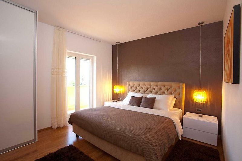 Camera da letto con arredamento in legno e illuminazione accogliente.
