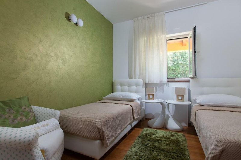 Camera da letto con arredamento in legno, comfort e finestra luminosa.