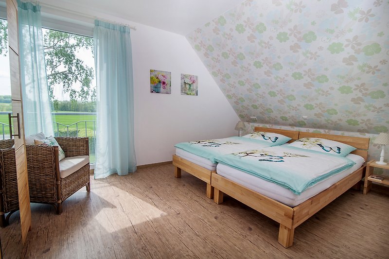 Gemütliches Schlafzimmer mit Holzbett und Fensterdekoration.
