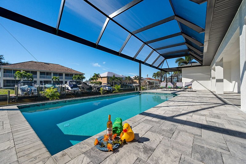 Schwimmbad mit Sonnenliegen und moderner Architektur.
