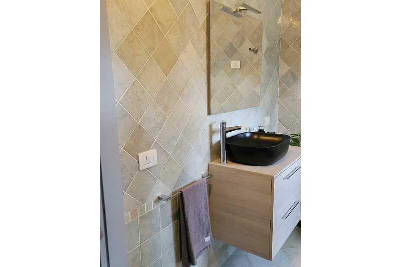 Modernes Badezimmer mit Fliesen, Holzboden und stilvoller Einrichtung.