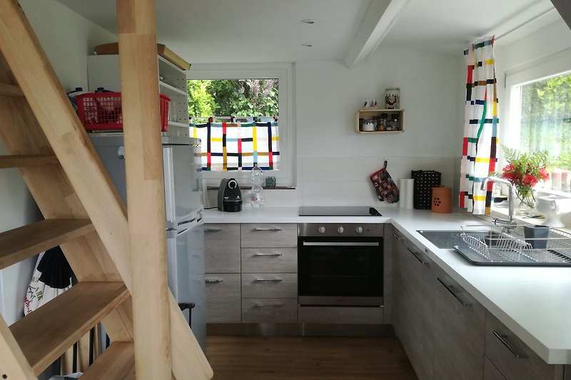 Gemütliche Küche mit Holzschränken, Fenster und Küchenspüle.