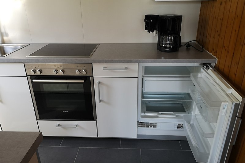 Moderne Küche mit hochwertigen Geräten, im Bild Backofen, Kühlschrank mit Tiefkühlfach und Kaffeemaschine