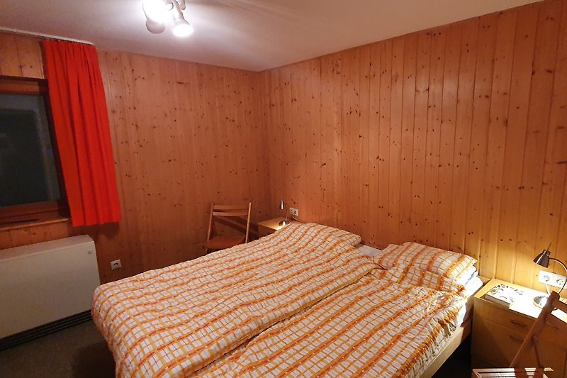 Gemütliches Schlafzimmer mit Holzmöbeln und zwei bequemen Einzelbetten.