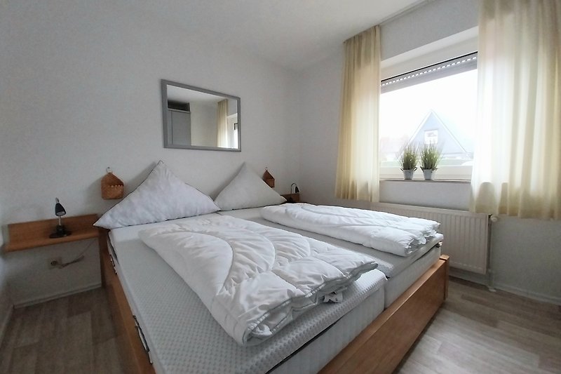 Schlafzimmer mit bequemem Bett, stilvollem Lampenschirm und gemütlichen Kissen.