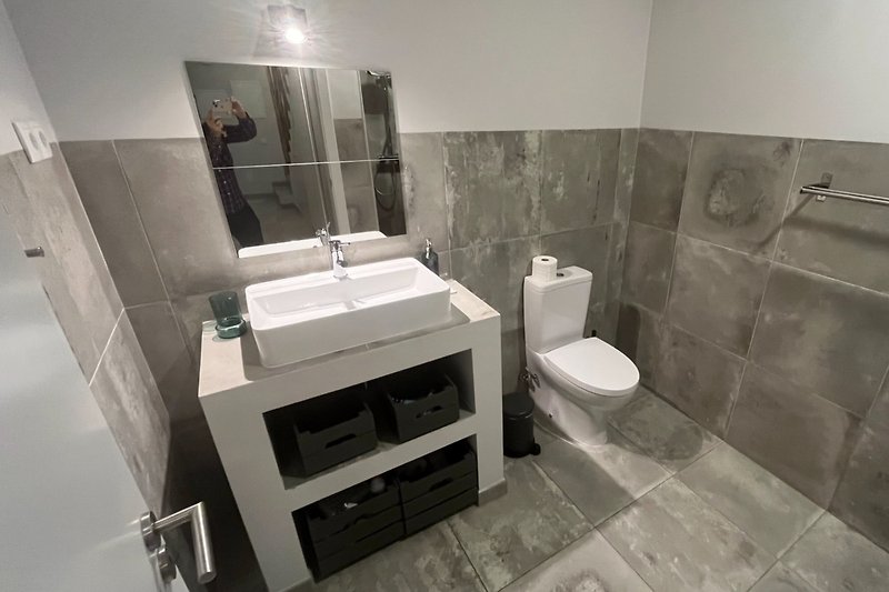 Modernes Badezimmer mit stilvoller Einrichtung und Spiegel