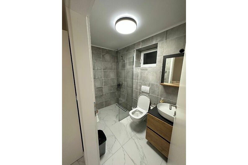 Elegantes Badezimmer mit Spiegel, Toilette und Waschbecken.