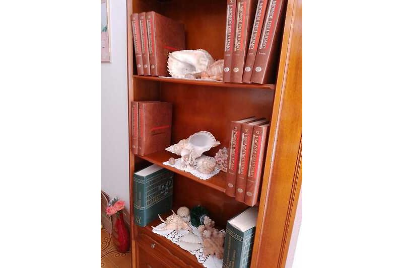 Holzregal mit Büchern, Taschen und Schachteln.