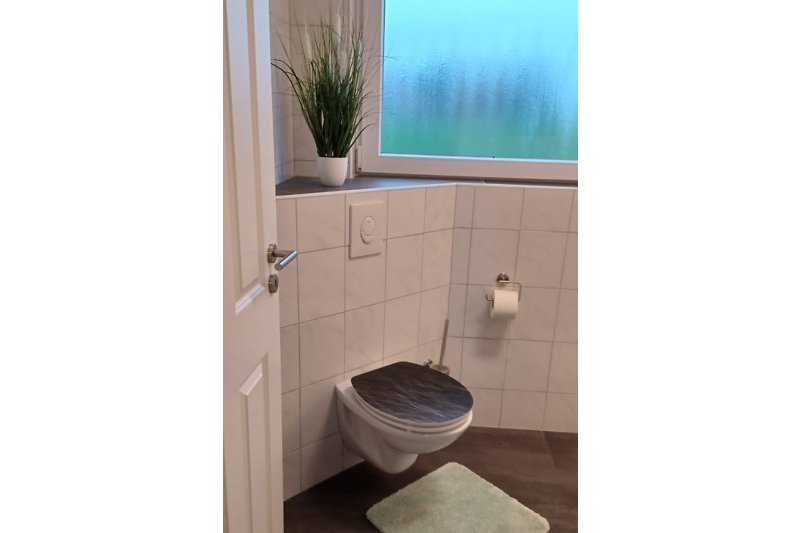 Badezimmer mit lila Akzenten und Holzdetails.