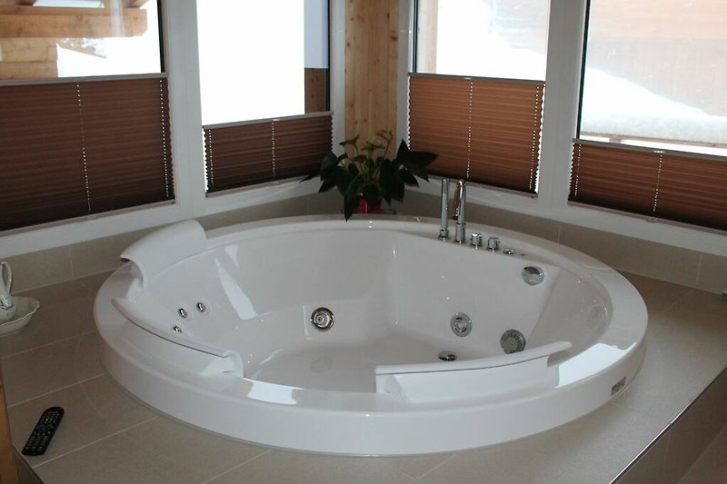 Luxuriöses Badezimmer mit Jacuzzi, Holzverkleidung und modernen Armaturen.