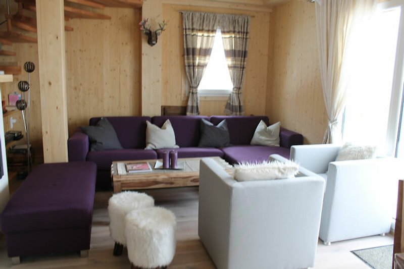 Wohnzimmer mit lila Akzenten, gemütlicher Einrichtung und Fensterblick.