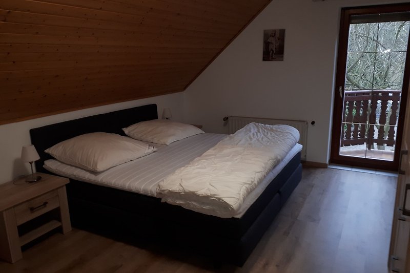 1 Schlafzimmer mit bequemem Bett, Holzmöbeln und Fensterblick.