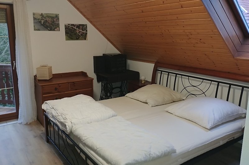 2 Schlafzimmer mit gemütlichem Bett, Holzmöbeln und Fenster.