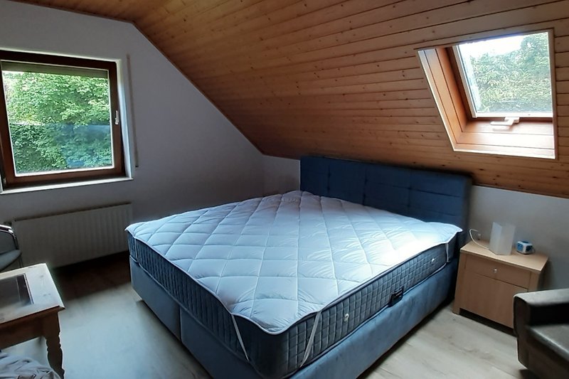 Schlafzimmer 3 mit bequemem Bett, Holzmöbeln und Fensterblick.