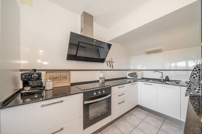 Modern kitchen with granite worktops and appliances, fully equipped.