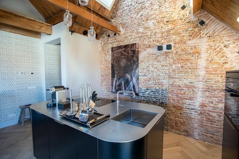 Moderne keuken met houten kasten en stenen muur.