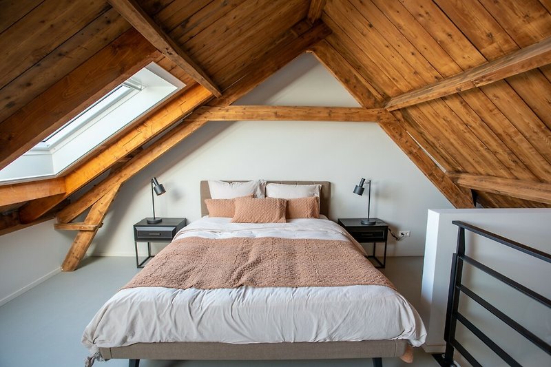 Sfeervolle slaapkamer met comfortabel bed en houten interieur.