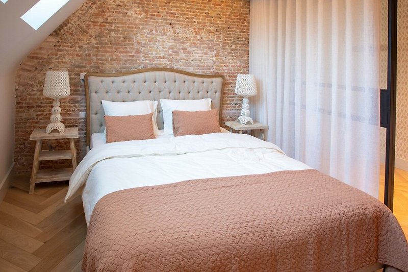 Stijlvolle slaapkamer met comfortabel bed en sfeervolle verlichting.