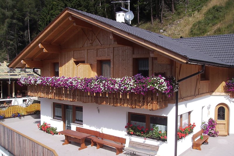 Charmantes Ferienhaus mit blühenden Pflanzen und Holzarchitektur.