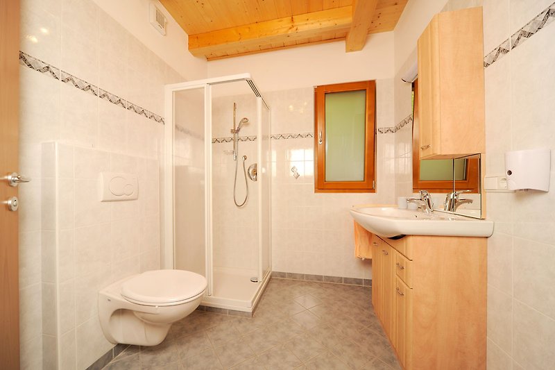 Badezimmer mit lila Akzenten, modernem Design und Glasdusche.