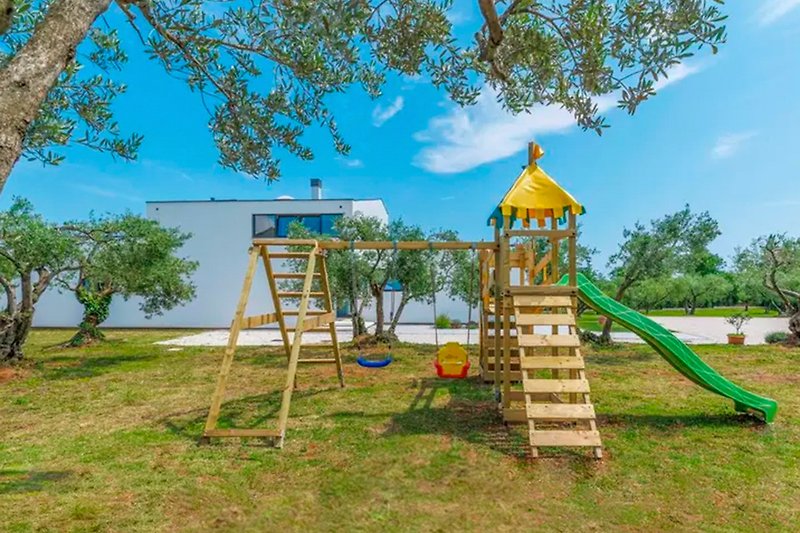 Fun playground with lush greenery, sky, and recreation.