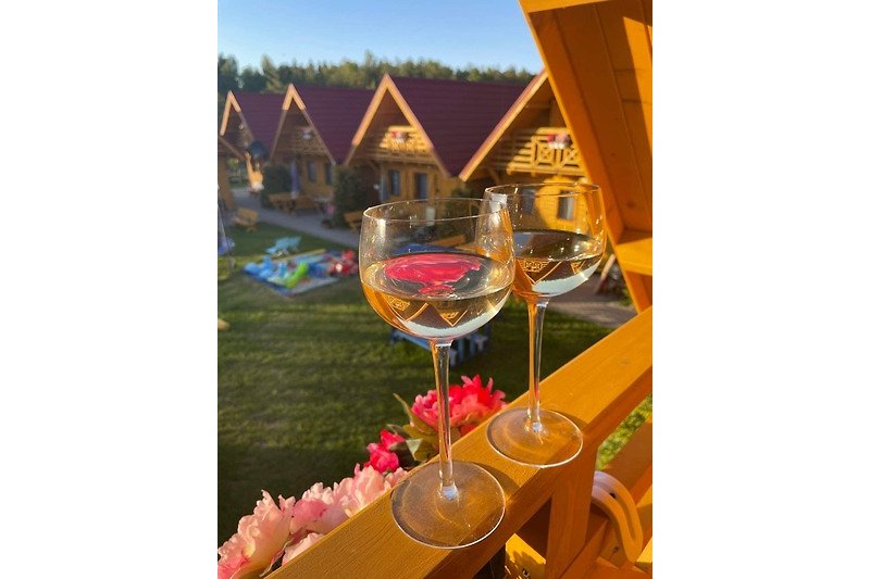 Elegantes Gartenfest mit Tisch, Stühlen, Glaswaren und Wein. Perfekt für Feierlichkeiten!