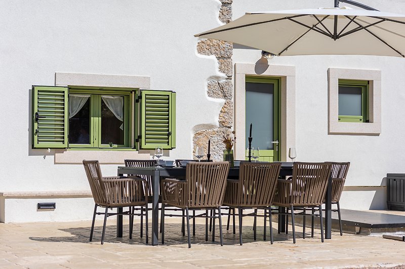 Elegante Terrasse mit stilvollen Möbeln und Sonnenschirm.