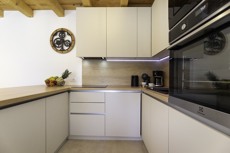 Moderne Küche mit eleganten Schränken, Arbeitsplatte und Küchengeräten.