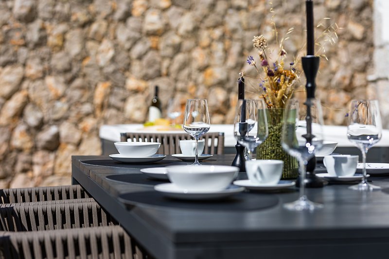 Elegante Tischdekoration mit stilvollem Geschirr und Blumen.