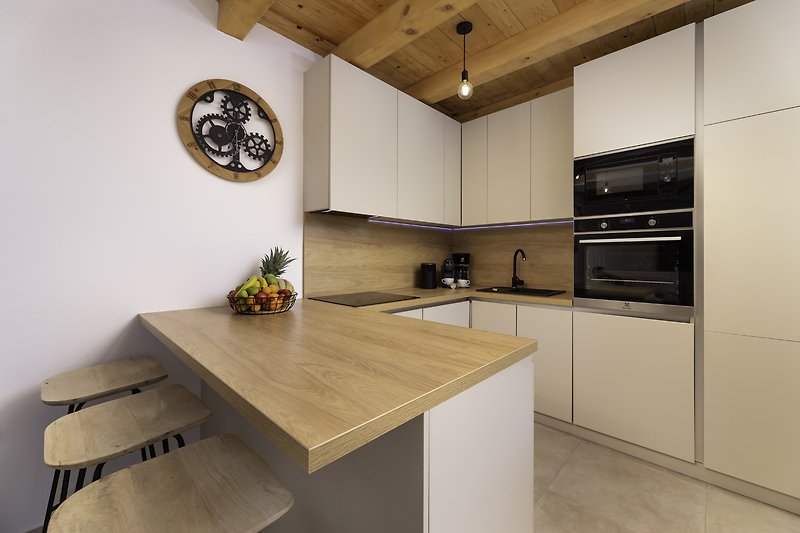 Moderne Küche mit eleganten Schränken und Holzarbeitsplatte.