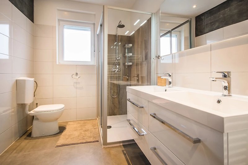 Luksuzna kupaonica s modernim umivaonikom i prozorom.