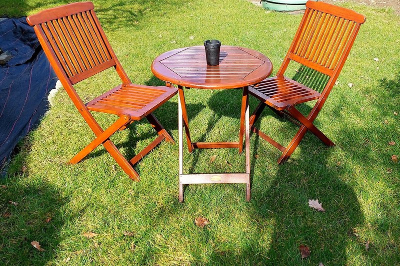 Holztisch und Stühle im Garten