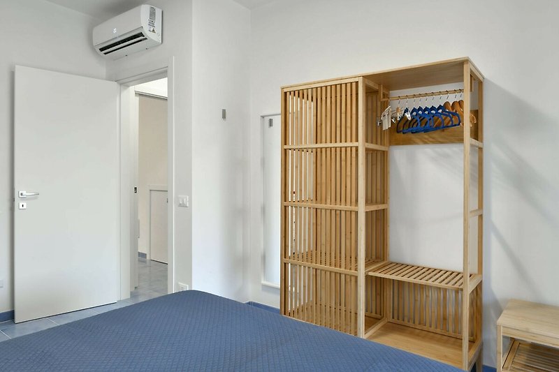 Modernes Schlafzimmer mit Etagenbett, Holzmöbeln und gemütlicher Bettwäsche.