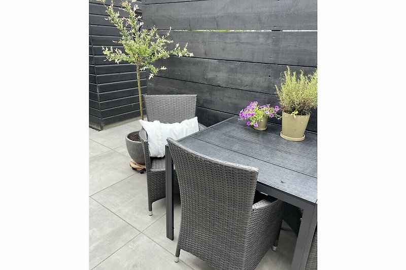 Prachtige tuin met tafel, stoelen en planten.