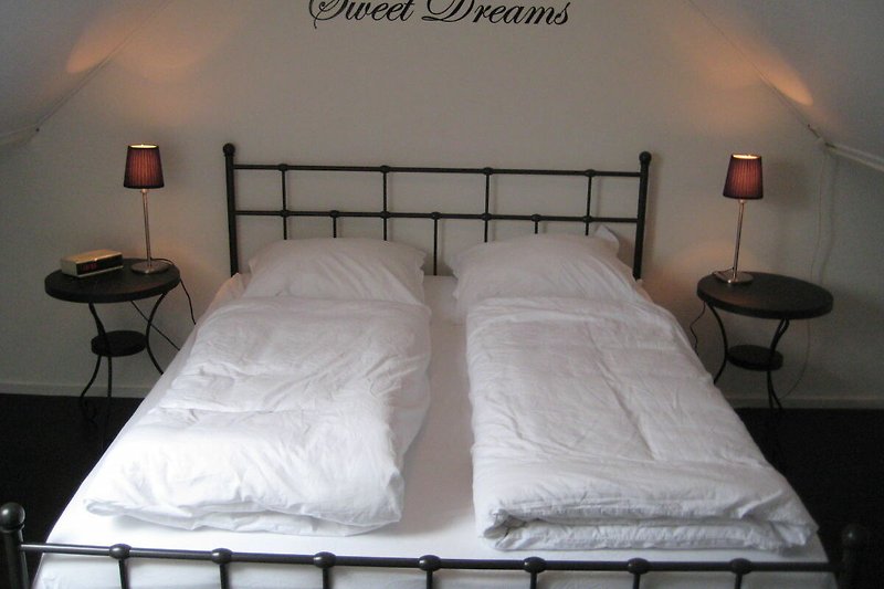 Stijlvolle slaapkamer met comfortabel bed en sfeervolle verlichting.