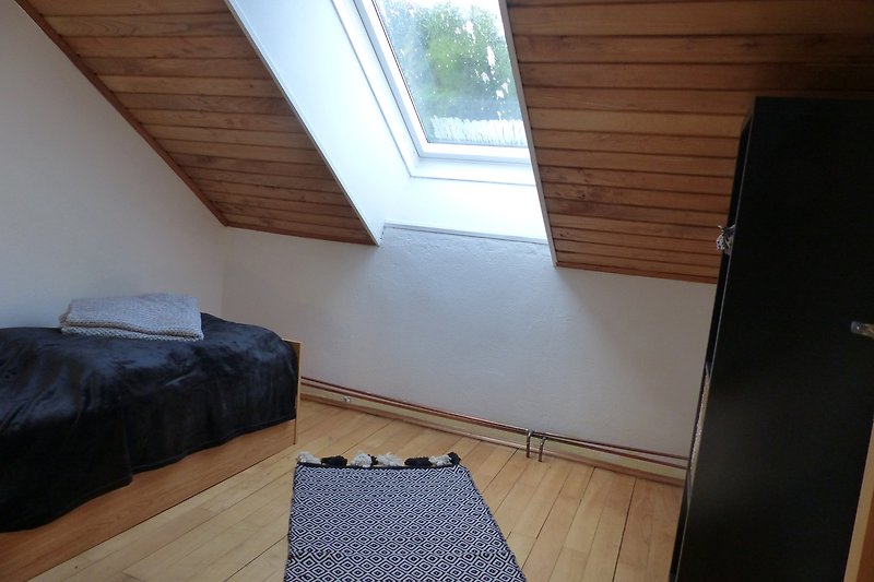 Geräumiges Wohnzimmer mit bequemer Couch und Holzbalken.
