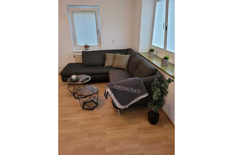 Stilvolles Wohnzimmer mit bequemer Couch, modernen Möbeln und Pflanzen.